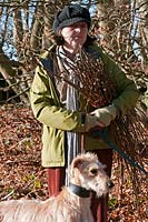 Annie Guilfoyle with a bundle of long sticks which she has collected from the wood.