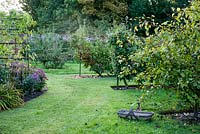 Apple orchard with espaliers and autumn border