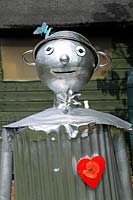 The Tin Man Scarecrow from The Wizard of Oz with colanders for hat and a red heart, Paddock Allotments 