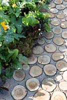 Log pathway leading through vegetable garden, Garden path made from sliced logs with gravel and sand infill 