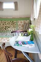 Pretty interior of a shepherds hut with books and reading chairs