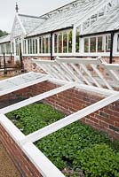Restored Victorian cold frames with glasshouses behind. 