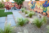 Garden surrounded by wall murals. Plants include Stipa tenuissima, Echinopsis pachinoi