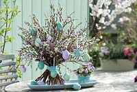 Salix, Betula, Larix and blossom of Hyacinthus strung on wire, decorated with crackle eggs, viola cornuta in pot