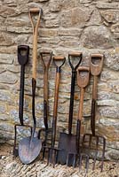 Collection of antique gardening tools: from left, clay spade, turf lifting spade, Irish potato fork, carrot fork, clay breaker spade, garden forks 