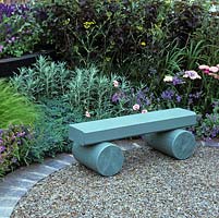 Innovative outdoor surface made from recycled rubber tyres. Wooden bench painted to blend into silver blue planting of juniper, artemisia , lavender and catmint.