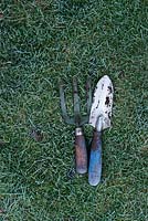 Frozen garden trowel and fork on a lawn in autumn - November - Oxfordshire