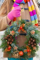 Girl with a home made Christmas wreath.