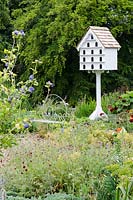 Dovecote by Gerry Peachey, Hibiscus syriacus 'Oisaeu Bleu' on left, border with Nigella, Knautia macedonica, Potentilla 'Etna', Penstemon 'Blackbird' - Mells Walled Garden, Somerset