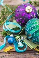 Peacock colour themed Christmas decorations. Baubles, ribbon and larch foliage