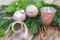 Champagne colour themed Christmas decorations. Baubles, ribbon, tea light holder, alder and yew foliage