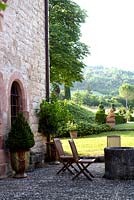 Long view of the garden at Domaine de Chatelus de Vialar.  The cobbled terrace in front of house including well-head.