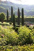 Long view of the garden at Domaine de Chatelus de Vialar.  Looking towards group of topiary yew. Peroskia in foreground.