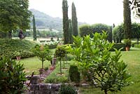 Long view of the garden at Domaine de Chatelus de Vialar.  Formal elements are in front of the house.  Looking towards group of topiary yew.   