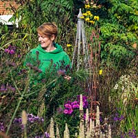 Anne Godfrey amongst the tall perennials in her garden.