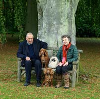 Lawrence and Elizabeth Banks with their three dogs, on a bench beneath a huge old beech tree planted a century ago.