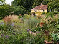 18th Century farmhouse overlooks walled garden filled with drought tolerant plants. 