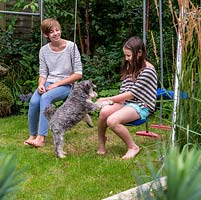 The two sisters, Scarlett, 13, and Lily, 10, play with their miniature Schnauzer dog, Alfie, 4.