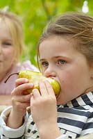 Girl eating freshly picked pear