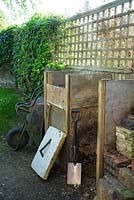 Two bin system for garden compost. Offcut of house insulation used as lid
