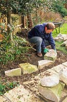 Man laying first course of dry stone wall