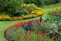 Summer bedding display with hot colour theme. Marigolds, tagetes, geraniums, petunias, zinnias, dahlias and rudbeckias