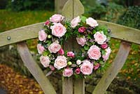 Pink roses in a two part circular arrangement on church lych gate for a wedding. Rose 'Keira' a cut flower variety from David Austin Roses