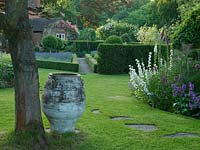 View past acer trunk and old terracotta pot to lavender and box parterre. Right bed has foxglove, campanula, bronze fennel and Stachys macrantha. Stepping stones in lawn.