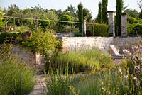 Perennial beds containing lavender and gaura surround the swimming pool terrace. At Bel Pech, Castelnau de Montmiral, Tarn, Midi Pyrenees, France. 