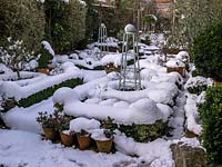 Snow covered small walled formal garden 