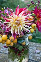 Yellow and pink Dahlia with yellow crab apples and hawthorn in glass jar
