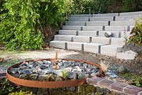 Poured concrete terracing with slate insets at the back of the house for use as steps or seating. Caervallack Farm, nr Helston, Cornwall, UK