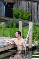 Man relaxing in swimming pond.