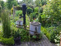 Pump and Victorian watering cart in formal kitchen garden.