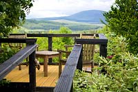 Seating area on elevated decking platform with view of hills