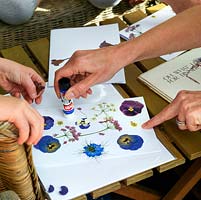 The garden flowers that two young girls picked two weeks before are now dry, and ready to make into a Mother's Day card. The flowers are delicate, so it's best to apply glue direct to the paper, and then stick the flower. A little adult help is needed for this bit
