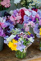 Small posies made up from summer flowers such as marigold, fragrant sweet pes, sweet William, scabious, feverfew, clary sage, achillea, cosmos, cornflower, ammi and feverfew.