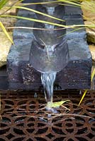 Rustic stone water feature with metal grill