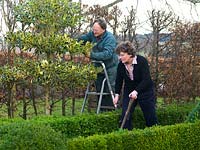 Simon and Kathy Brown working in the formal French garden with its clipped boxed parterre, yew topiary and holly tiers.