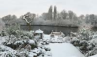 River Thames garden designed by Andy Sturgeon. Box topiary, grasses and architectural plants covered in snow.
