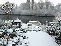 River Thames garden designed by Andy Sturgeon. Box topiary, grasses and architectural plants covered in snow. 
