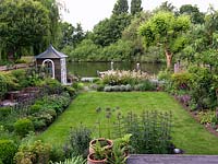 Riverside garden by Andy Sturgeon. Left bed - oak cubes, allium, erysimum, Hebe vernicosa, box, iris, aquilegia, fern, nandina, mahonia. Far - libertia, iris, euphorbia, santolina.