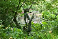Oberon and Titania sited near the pond in the woodland garden. King John's Nursery, Etchingham, East Sussex, UK
