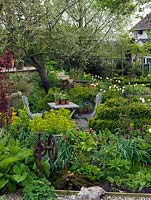 Quiet seating area amidst borders of tulips, daffodils, hellebores, ragged robin, euphorbia and ferns. To the left up steps, top deck.
