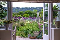 View Through french windows to a large early summer border.  This garden was planted only two years before these images were taken.