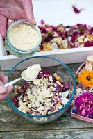 Making potpourri step by step. Fragranced orris root power is then added to the dried flowers and petals.