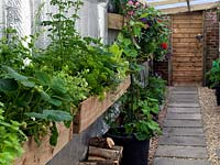 Covered side passage is planted with window boxes of herbs, strawberries and flowers.