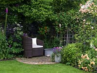 A secluded seating area under a Magnolia tree and by a small container pond.