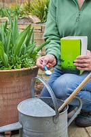 Adding plant feed to watering can
