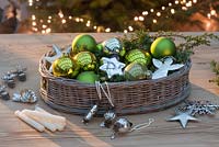 Green and silver Christmas tree decorations - balls, silver stars, angels, snow crystals, candle holders and candles with basket